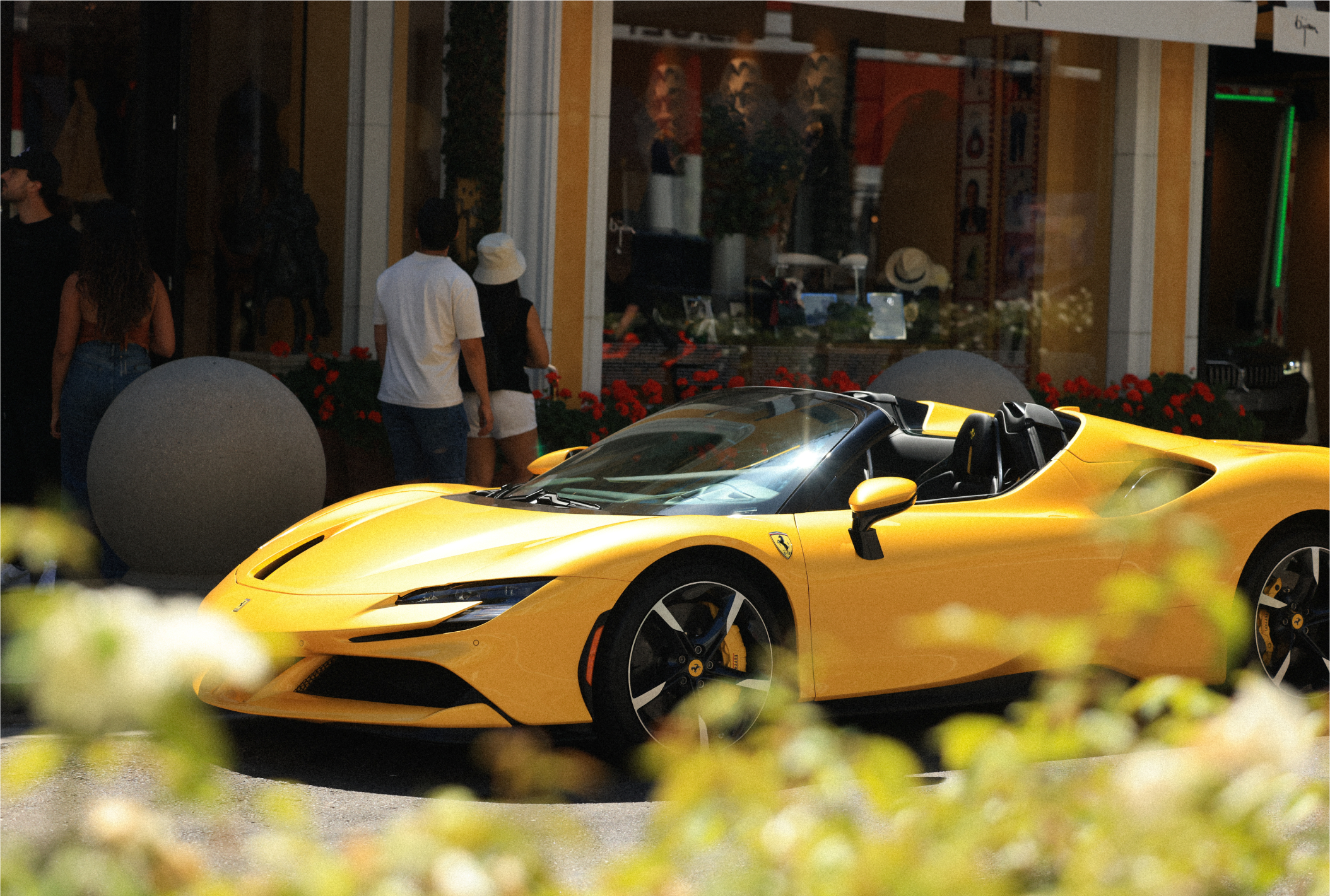 a yellow sports car parked in front of a store