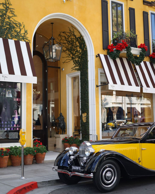 a yellow and black car parked in front of a building