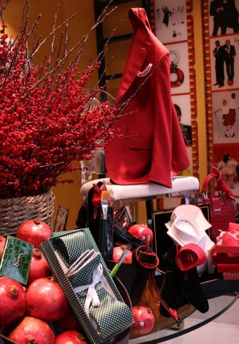 a table with a basket of apples and a red coat