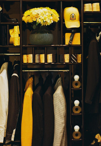 a closet filled with lots of clothes and a vase of flowers