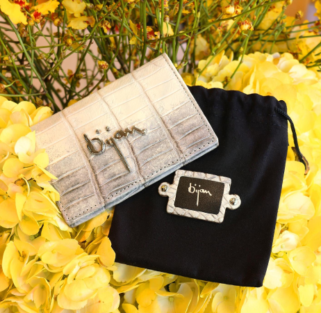 a silver purse sitting on top of a black bag